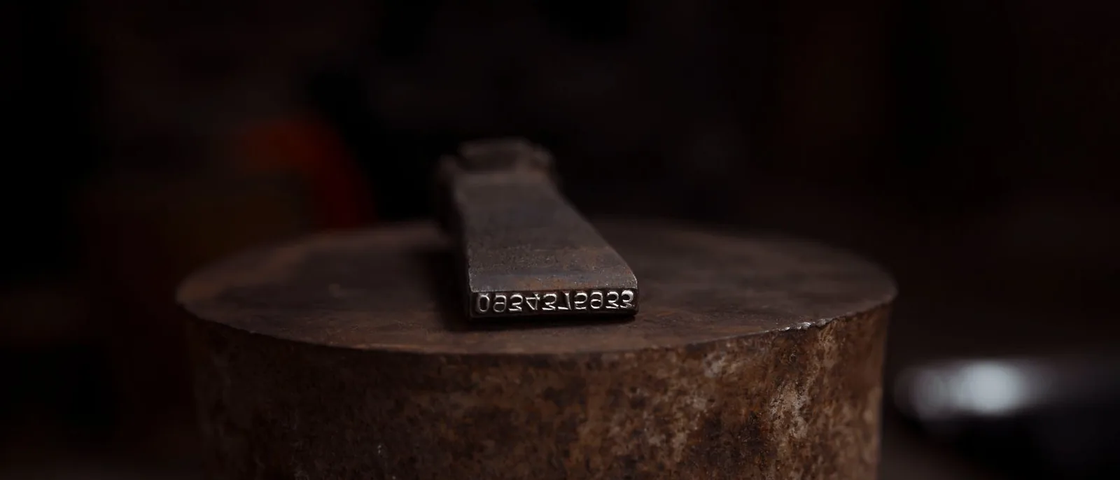 A worn maker's stamp on dark metal