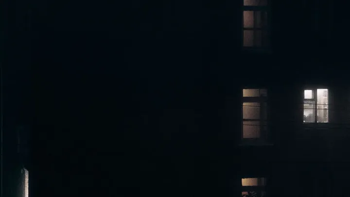 One lit window in a dark facade
