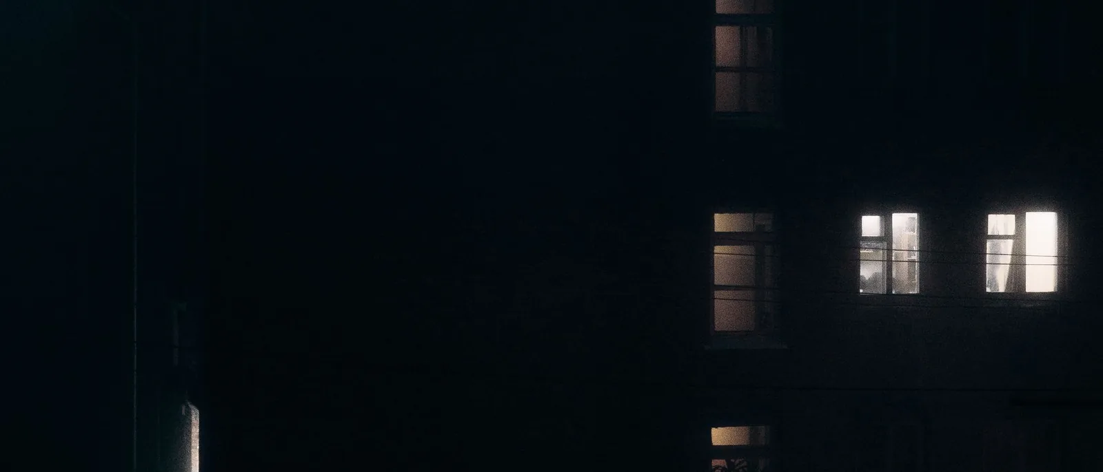 One lit window in a dark facade