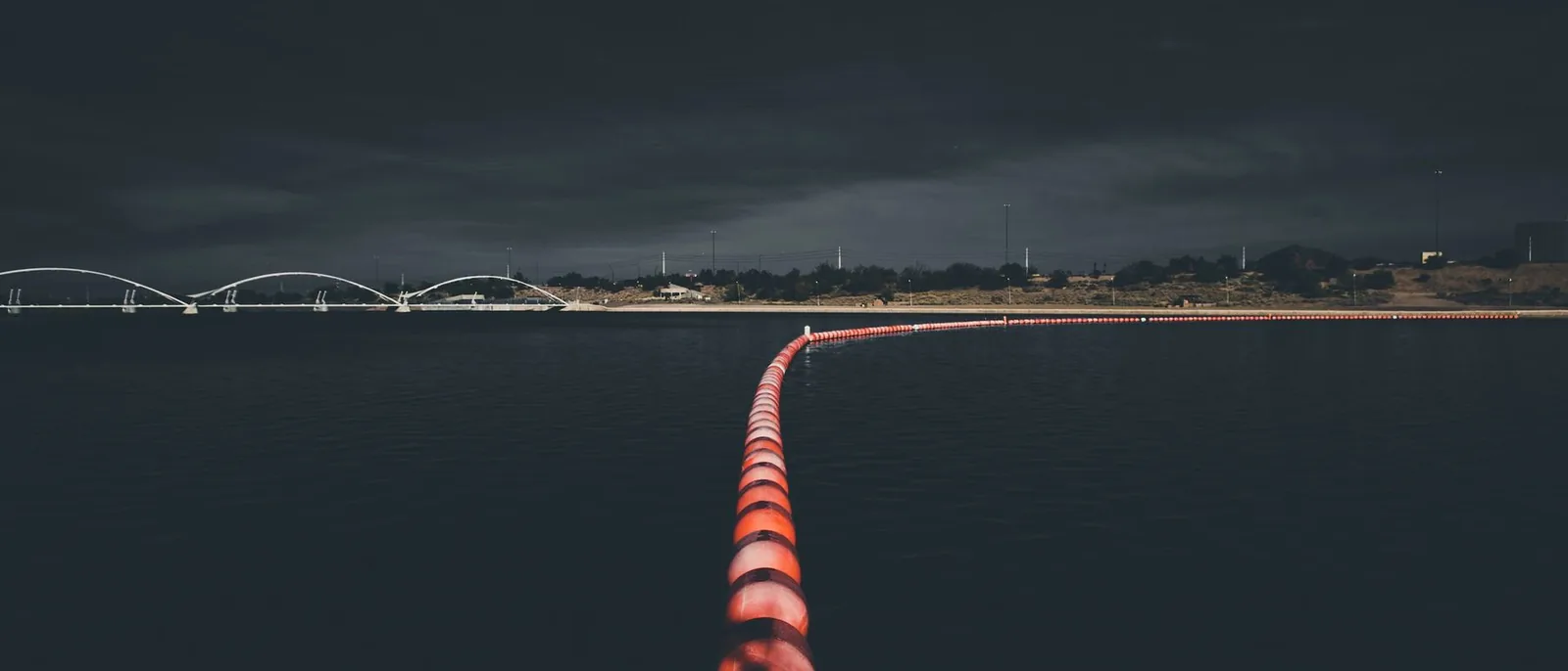 A line of marker floats curving away across dark water