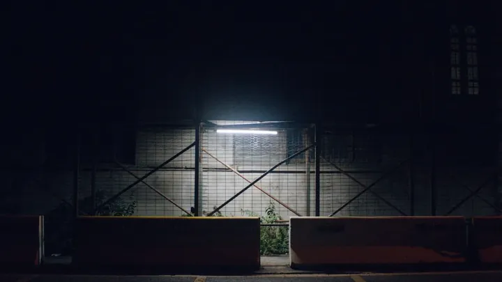 A shopfront lit hard against a dark street