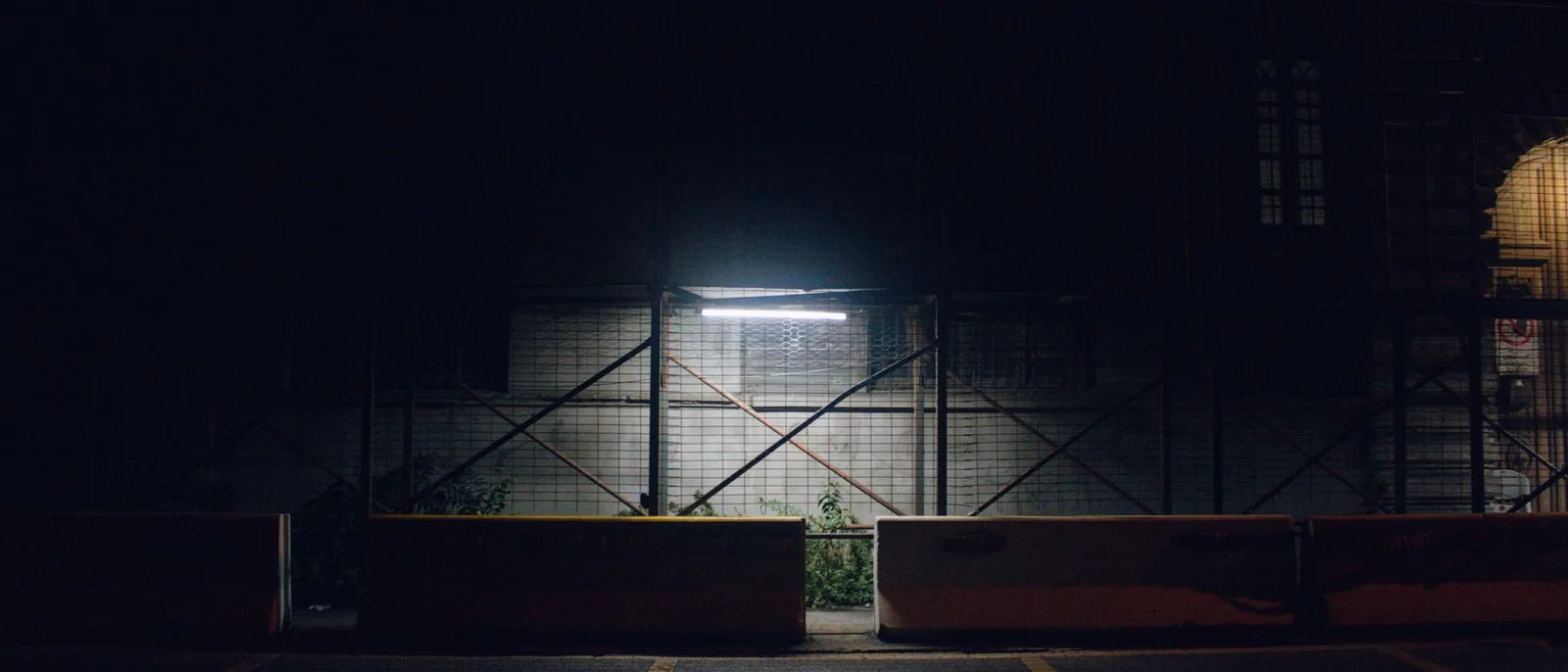 A shopfront lit hard against a dark street