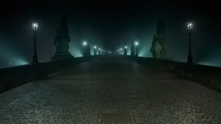 An old stone bridge at night in fog
