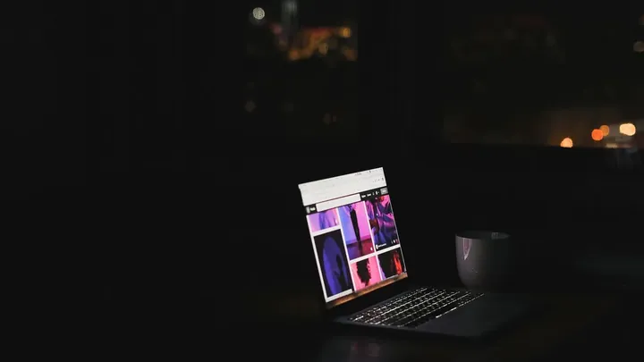 A single lit laptop in an otherwise dark room
