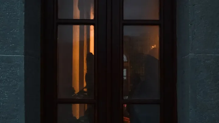 A single lit window seen from the street