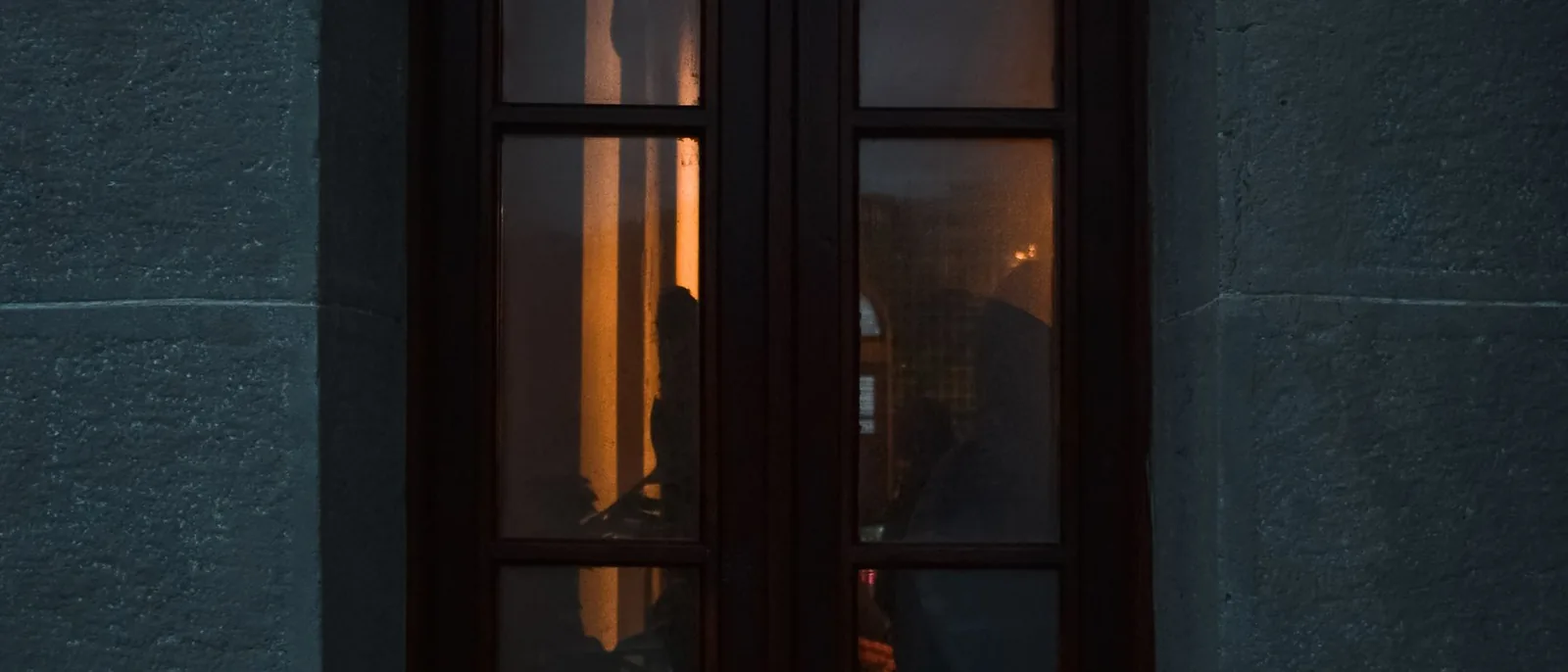 A single lit window seen from the street